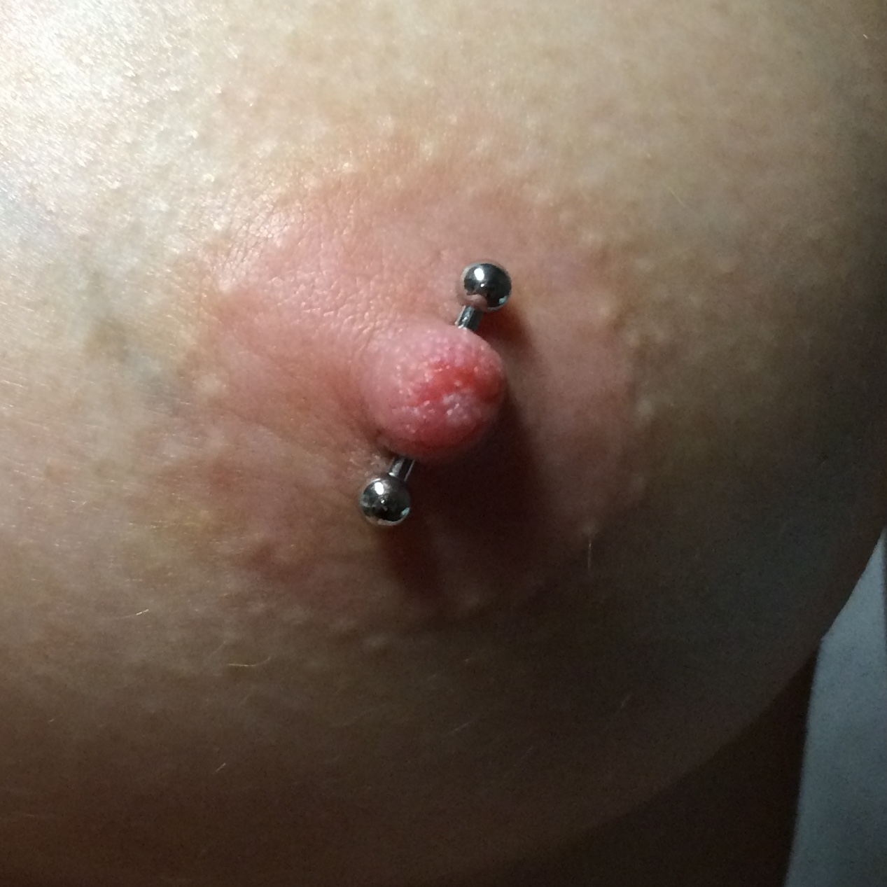 Female nipple piercing at an alternate (outward diagonal) angle