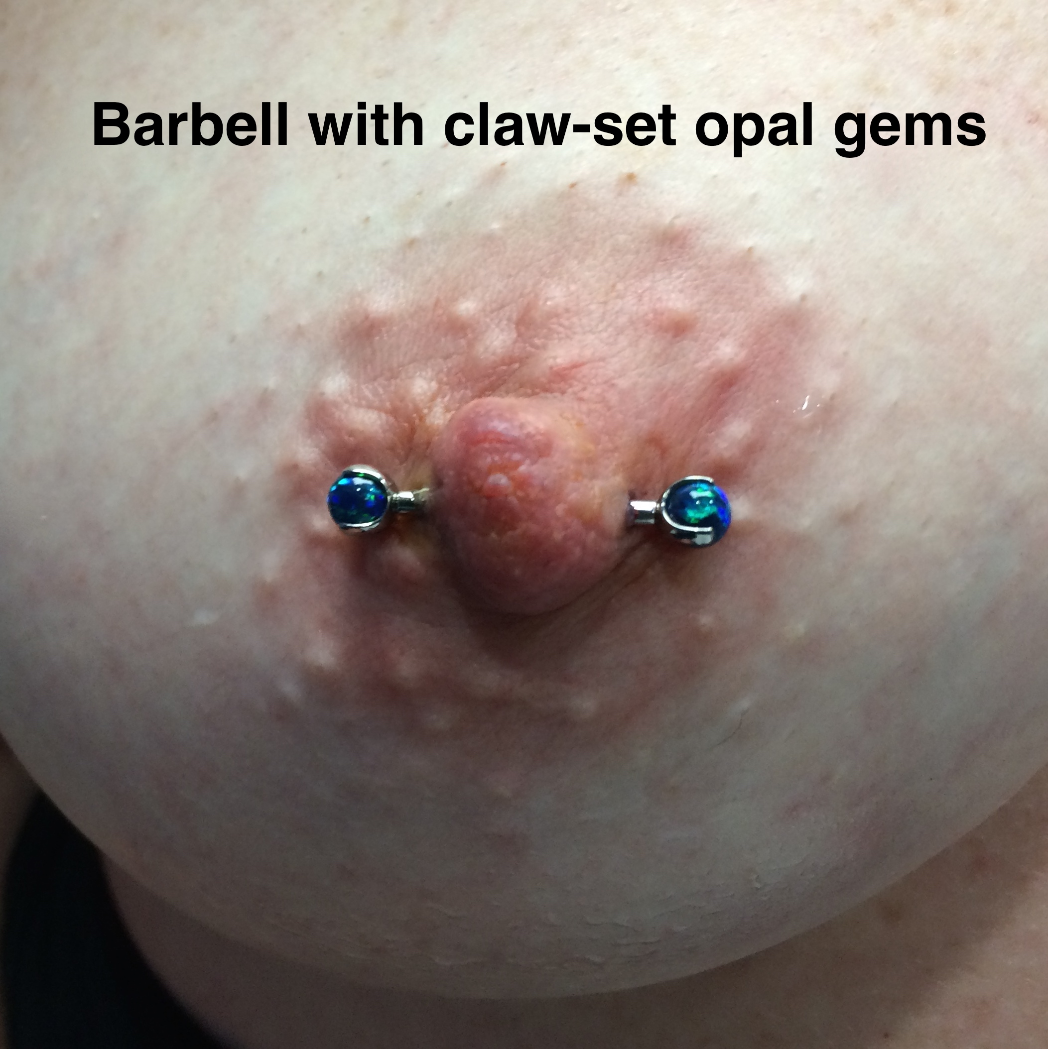 A female nipple piercing with blue claw-set opals on the barbell