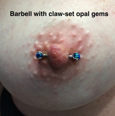 A female nipple piercing with blue claw-set opals on the barbell