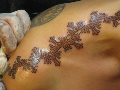 Getting my Mayan sun ray tattoo across the tops of my shoulders, by Walt Clark in 2010, for my 50th birthday