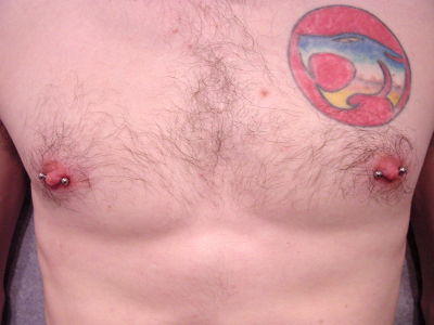 A pair of male nipple piercings with barbells