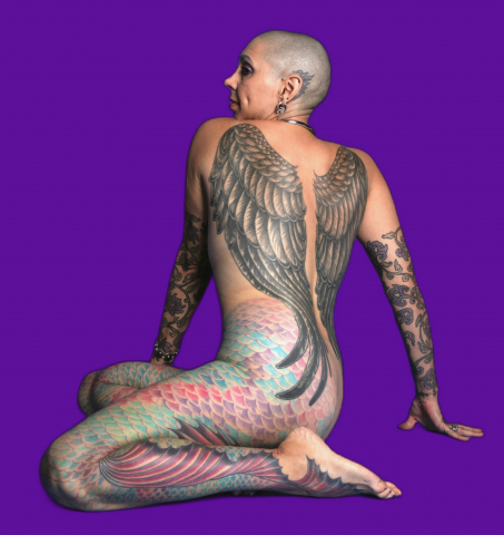 Elayne Angel with body art on display on a \ Purple Background